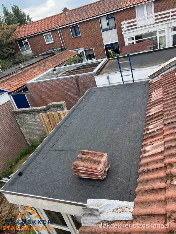Plat dak aanbouw met bitumen naast schuin pannendak in Stadskanaal Plat dak aanbouw met bitumen naast schuin pannendak in Stadskanaal