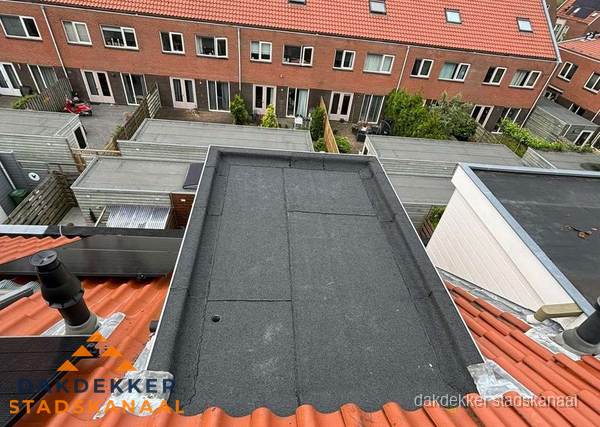Plat dak met bitumen bedekking naast dakkapel in Stadskanaal