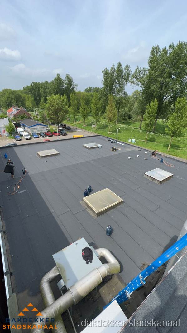 Dakdekker aan het werk op groot plat dak met bitumen in Stadskanaal Dakdekker aan het werk op groot plat dak met bitumen in Stadskanaal
