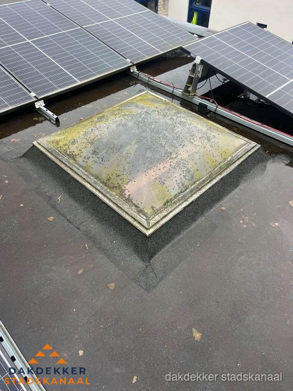 Vervuilde lichtkoepel op plat dak met zonnepanelen in Stadskanaal Vervuilde lichtkoepel op plat dak met zonnepanelen in Stadskanaal