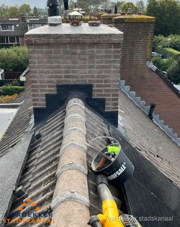 Schoorsteen met loodaansluiting en nokvorst op pannendak in Stadskanaal