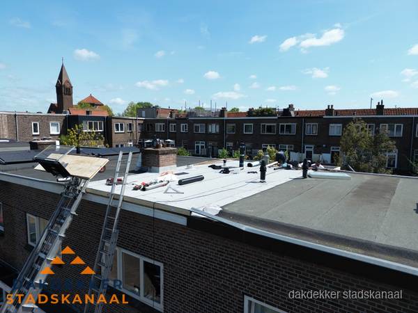 Dakdekkers aan het werk op plat dak in Stadskanaal