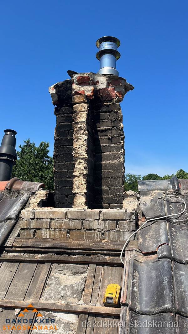 Beschadigde schoorsteen met nieuwe rookgasafvoer op oud dak in Stadskanaal Beschadigde schoorsteen met nieuwe rookgasafvoer op oud dak in Stadskanaal