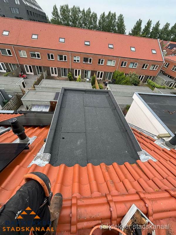 Bitumen dak reparatie op plat dak tussen dakpannen in Stadskanaal
